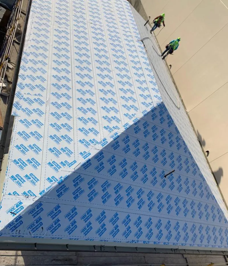 Professional roofers installing underlayment on a metal roof in Beckett Ridge